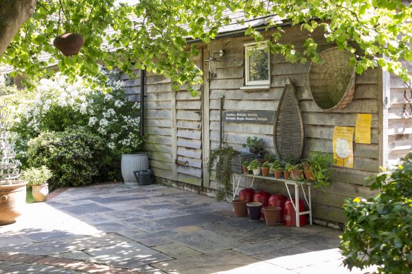 Add an old sign to your shed and display pots outside it